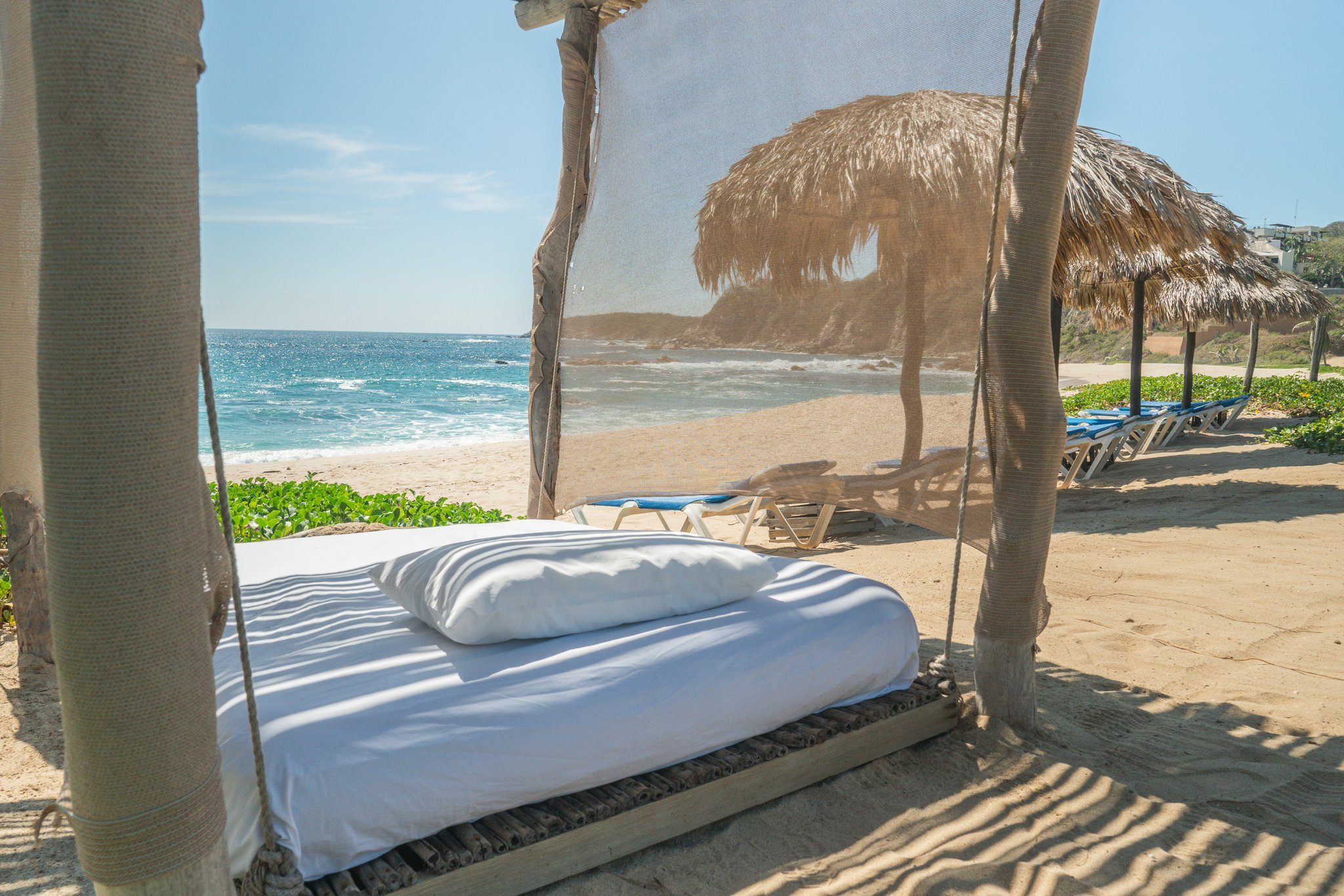 A beach daybed under the palapa, facing the Pacific