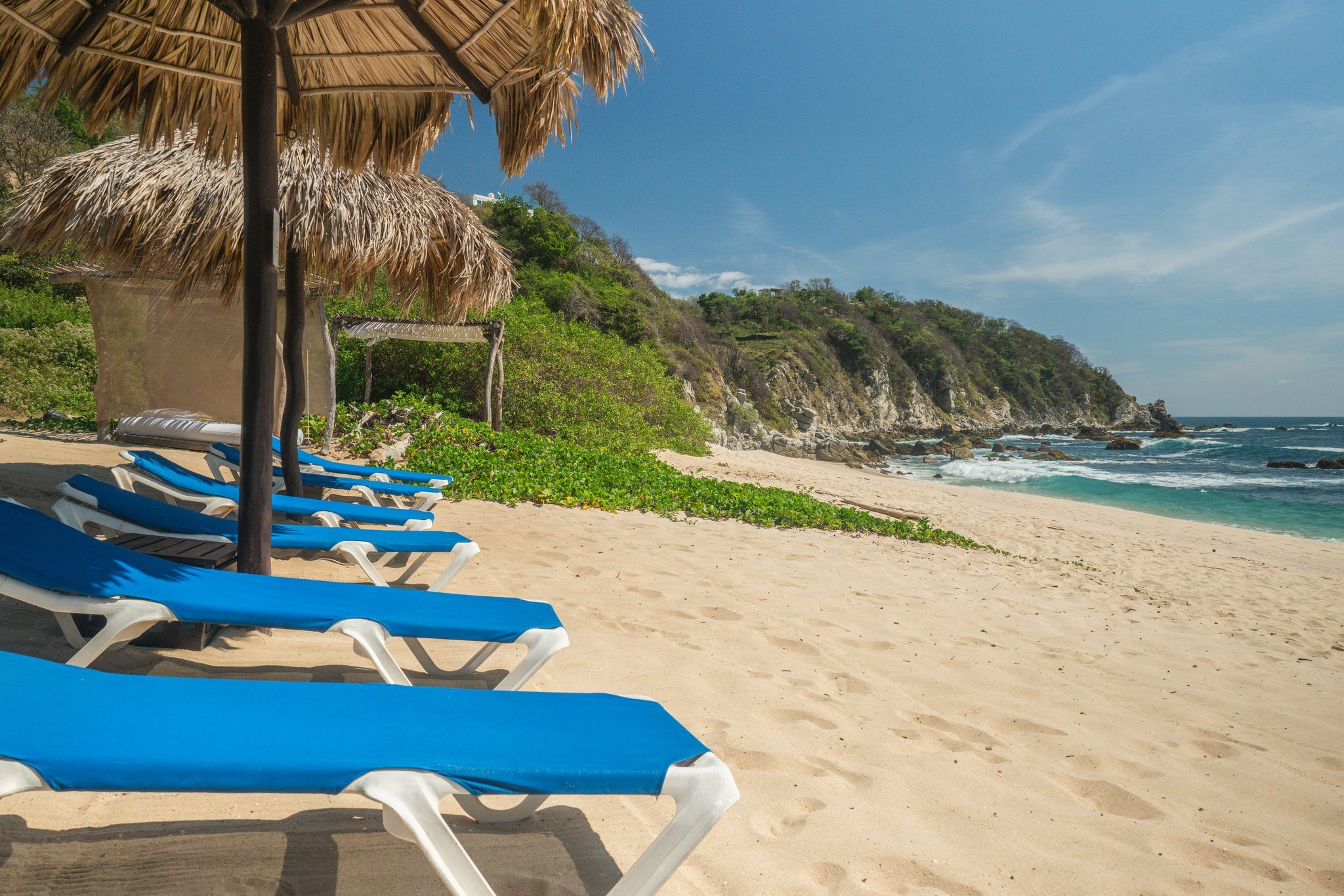 Sun loungers under palapas on the beach