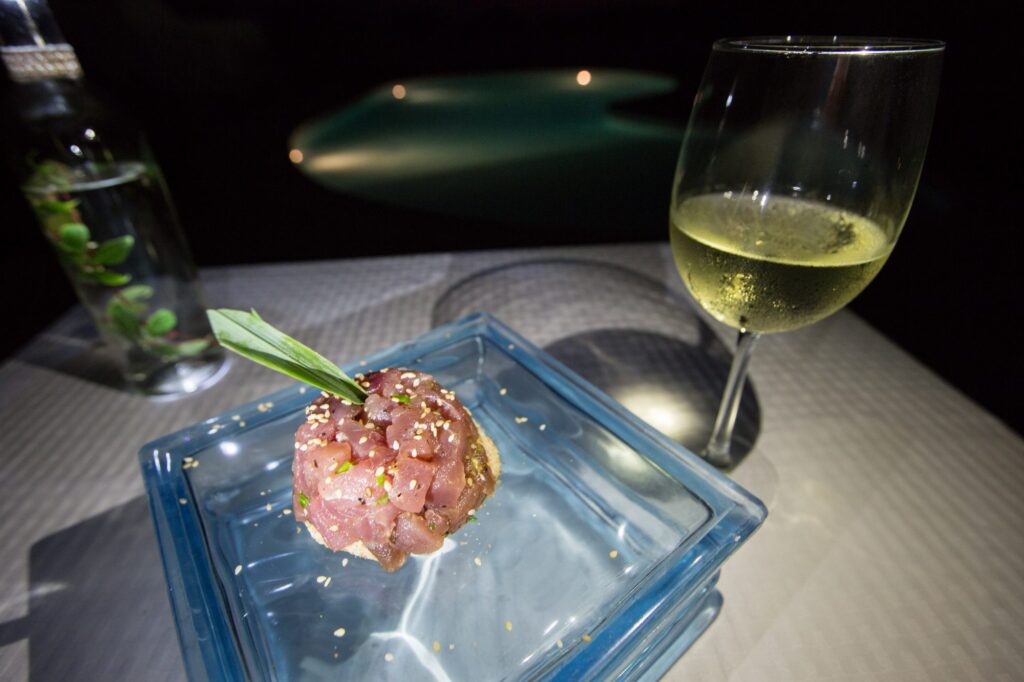 Tuna tartare on a glass block, served at night with white wine