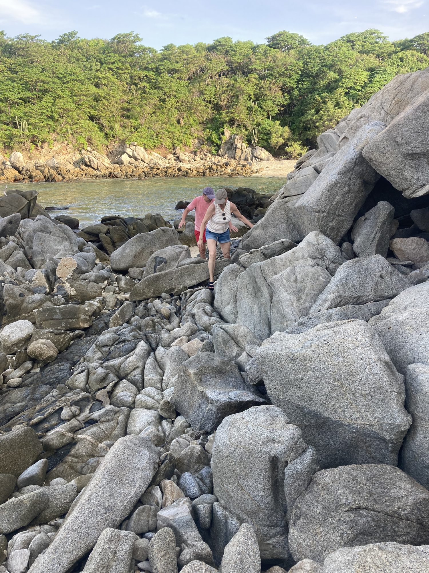 Escalade de rochers de granit vers une crique cachée
