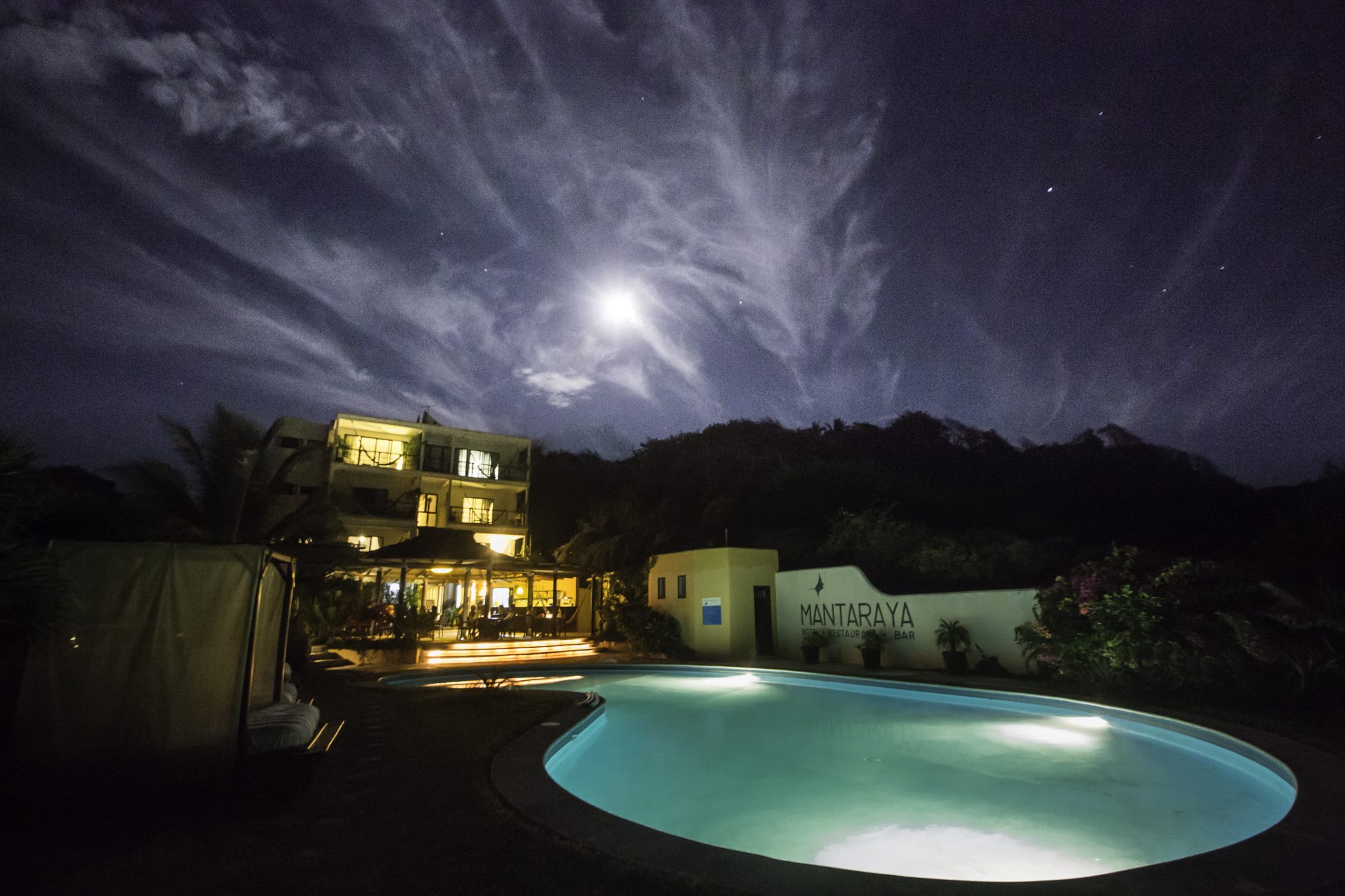 L’hôtel et la piscine sous un ciel éclairé par la lune